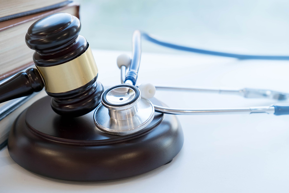 A wooden gavel with a stethoscope laying next to it