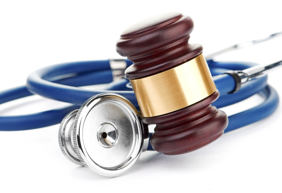 Brown gavel and a medical stethoscope on white background